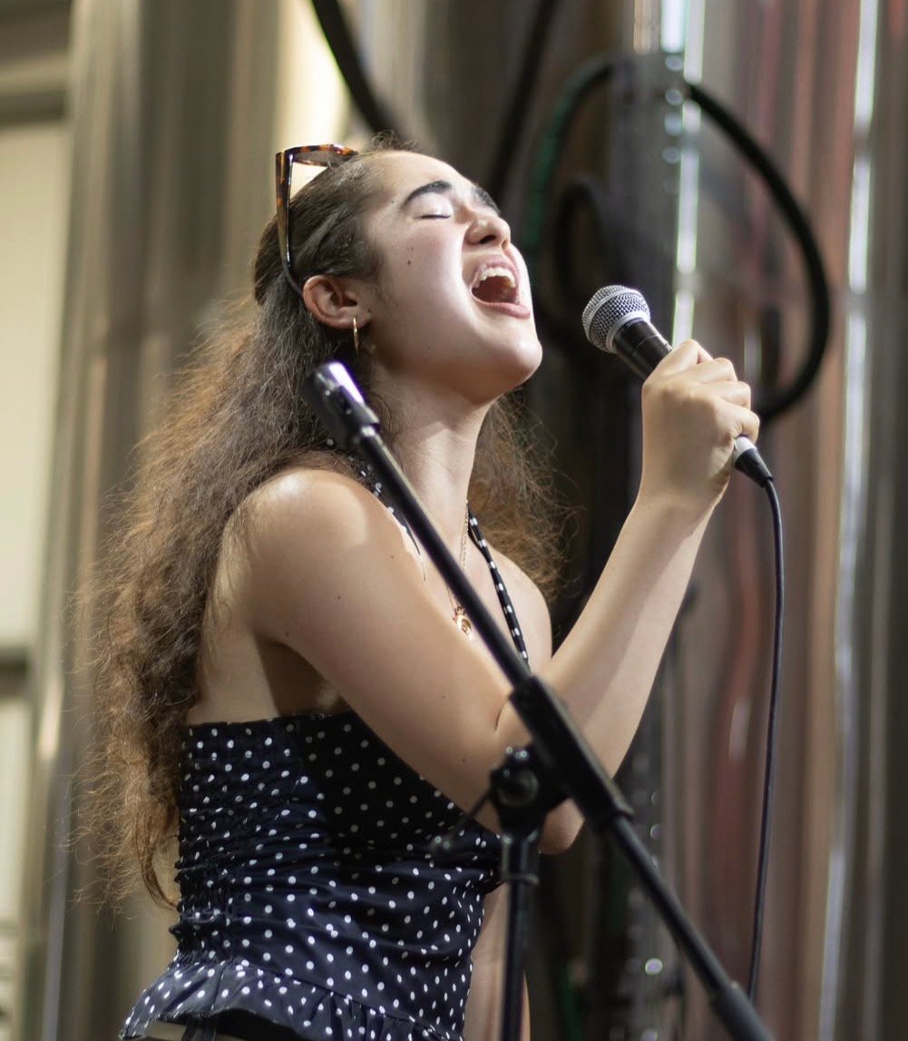 Rosie performing live, singing into a microphone