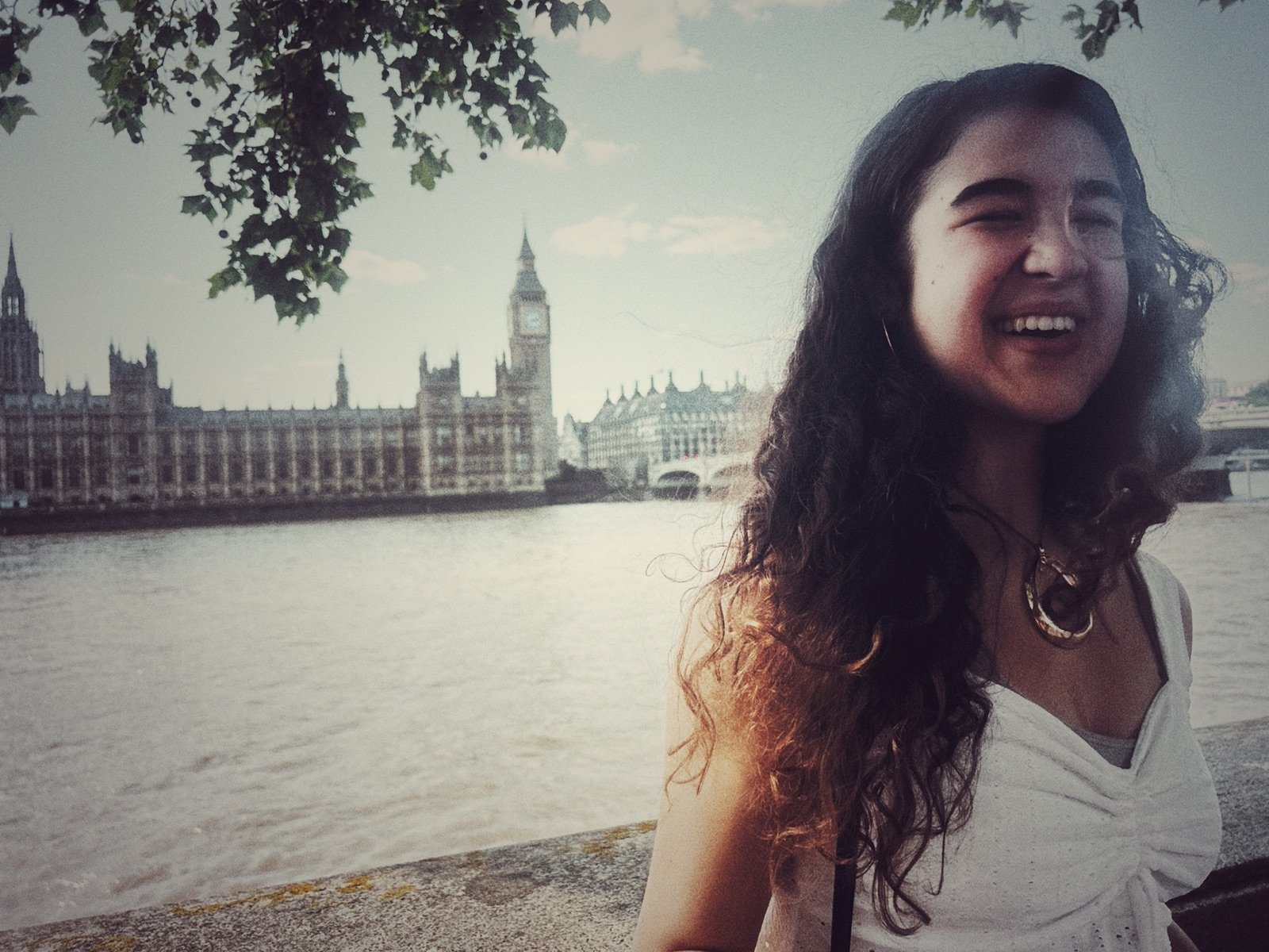 Rosie laughing by the Thames with Big Ben behind her